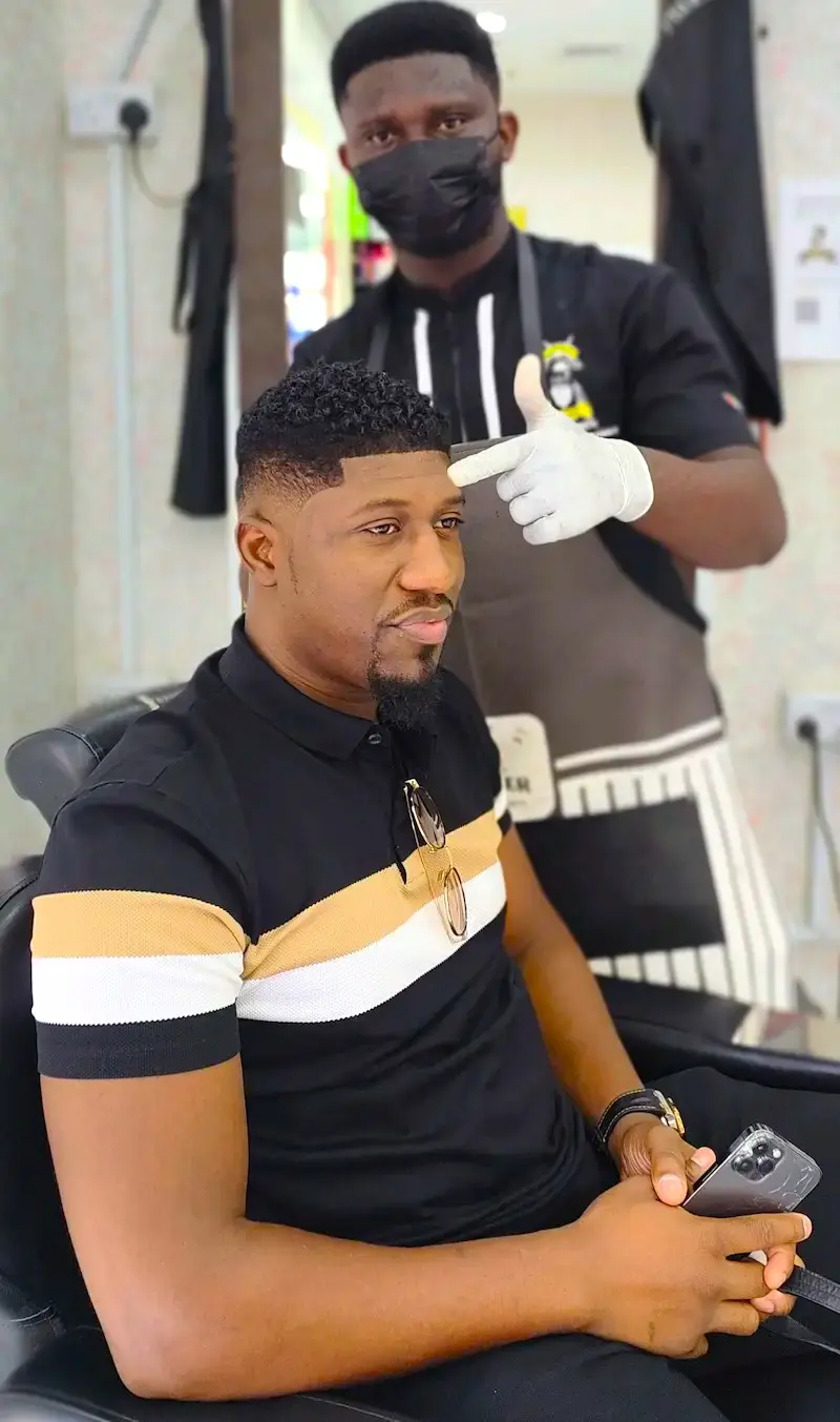 barber giving clean fade haircut to client at Kings Afro Barbershop in JVC Dubai