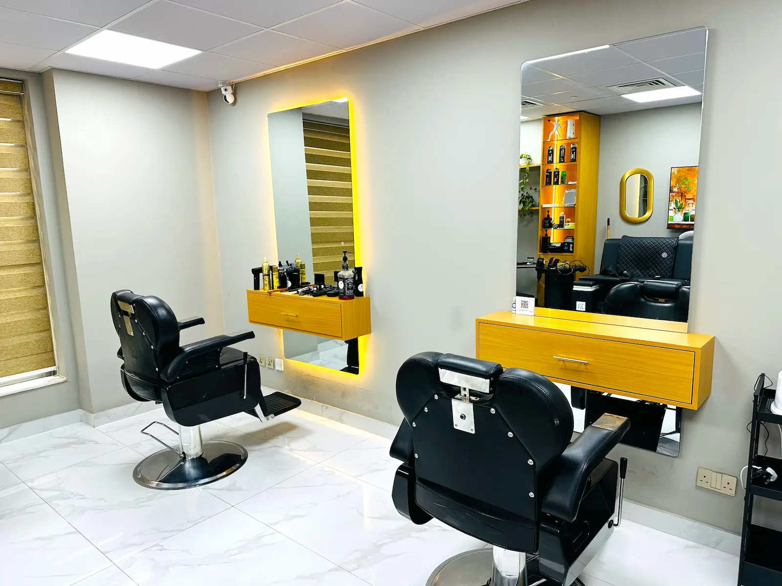 modern barber shop interior with chairs and mirrors at Kings Afro Barbershop in Dubai